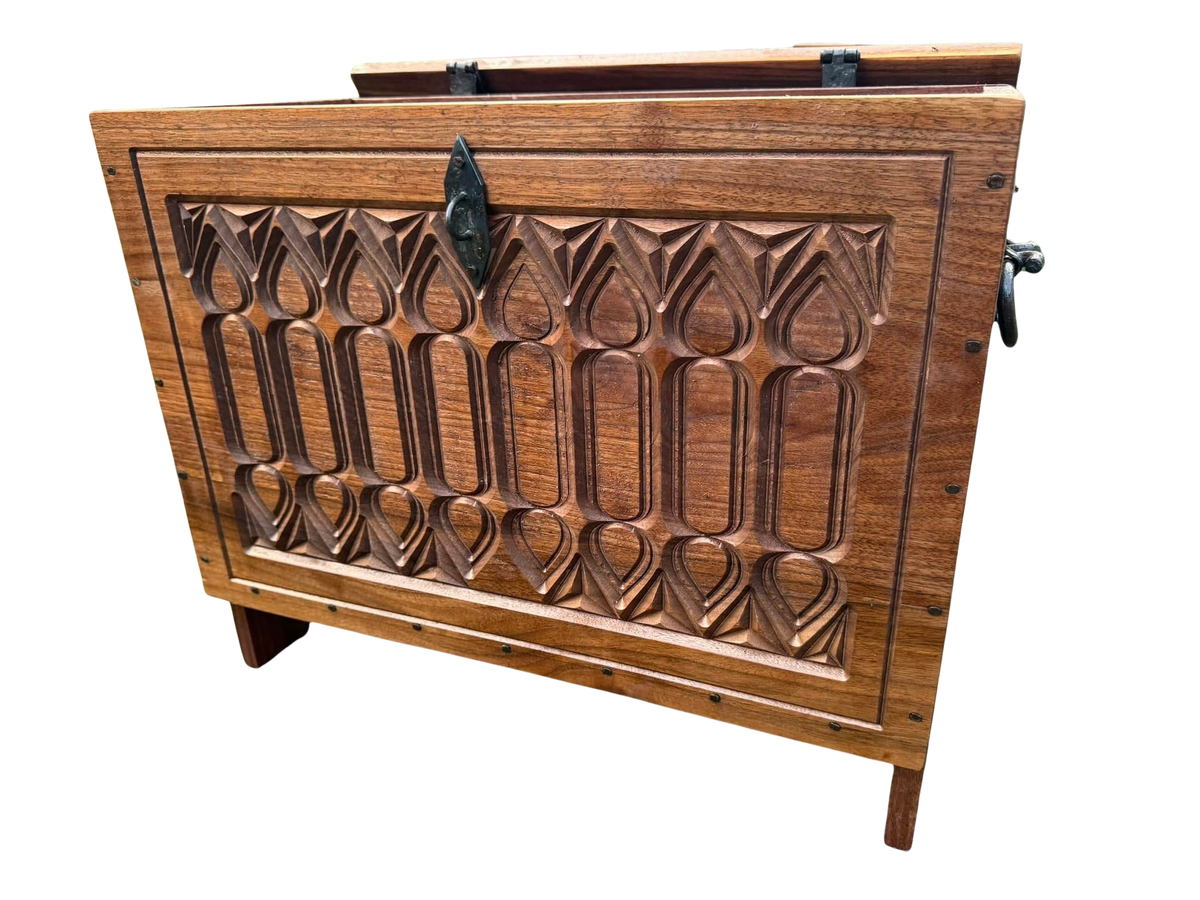 A carved gothic style wooden chest with hand forged hardware.