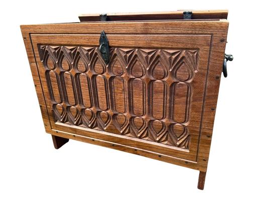 A carved gothic style wooden chest with hand forged hardware.